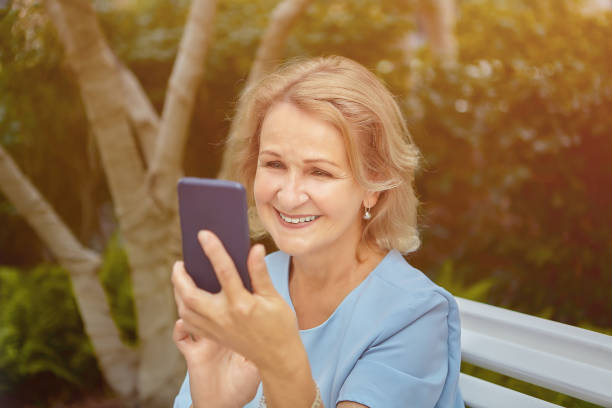 istock Elderly attractive white woman with cellphone. 1263891583