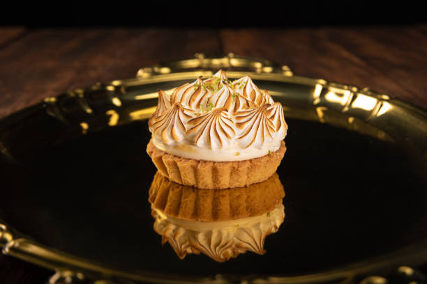 istock Lemon tart on a golden tray on rustic wood, selective focus 1263891685