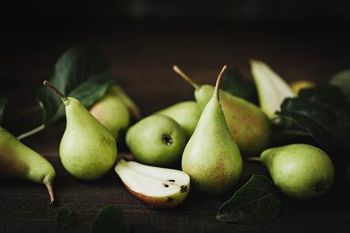Closeup of a freshly picked pears with half slice. Harvested pears on wooden table.