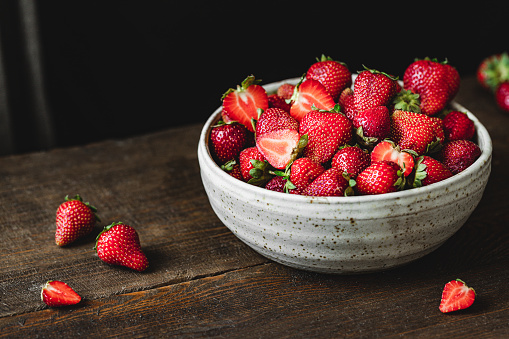 Strawberry fruits in a punnet on a grass and clover background