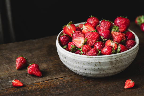 Bowl of fresh strawberries Close-up of bowl of fresh strawberries. Freshly harvested strawberries in a ceramic bowl over wooden table. strawberry photos stock pictures, royalty-free photos & images