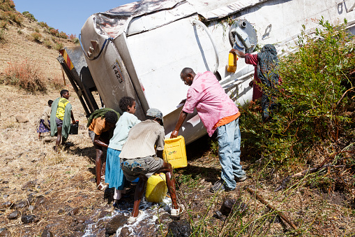Addis Abeba, Ethiopia, January 15 2015: Locals fill up their canisters with diesel that spills out of an overturned tanker truck