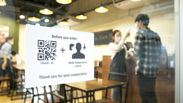 Check in and body temperature check paper sign measure in front of restaurant with staff scan body temperature and scan QR code for check in. New normal for protection covid-19 after reopening. el check-in y la temperatura corporal comprueban la medida del letrero de papel frente al restaurante con el personal escaneando la temperatura corporal y escaneando el código qr para el check-in. nueva normalidad para la protección covid-19 después de
