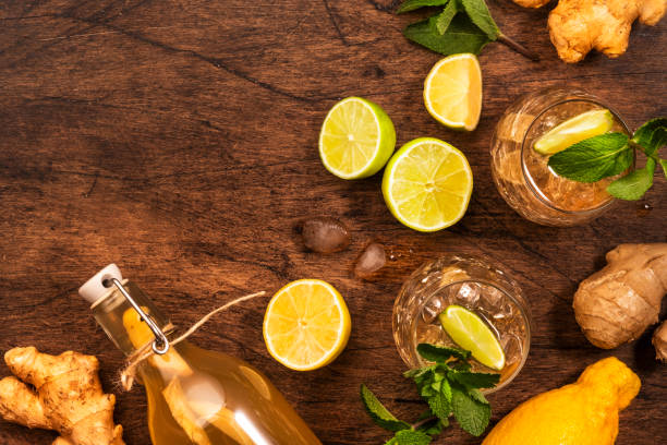 cocktail di birra ginger ale golden con lime, limone e menta in bicchieri su tavolo di legno, vista dall'alto con spazio di copia - ginger tea root hot drink foto e immagini stock