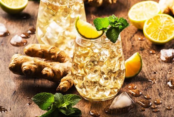 cocktail di birra ginger ale golden con lime, limone e menta in vetro su tavolo di legno, spazio di copia - ginger tea root hot drink foto e immagini stock