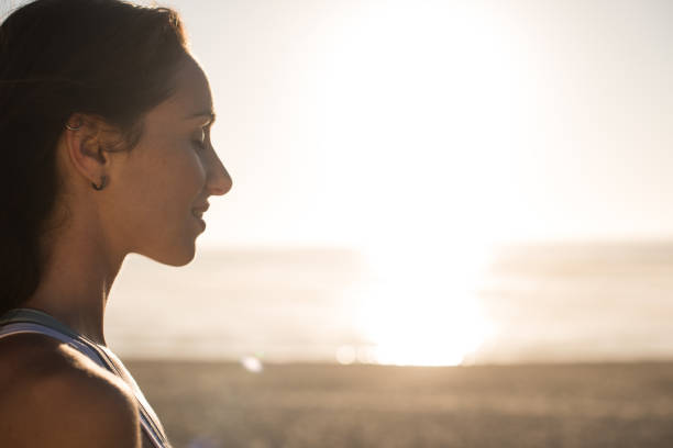 istock Woman enjoying beautiful sunset on the beach 1263901791