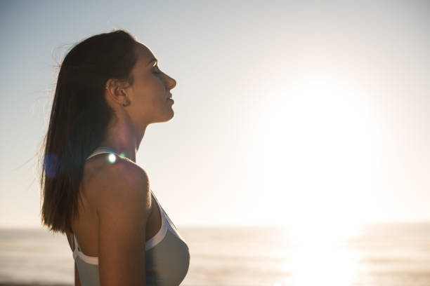 istock Woman enjoying beautiful sunset on the beach 1263901794