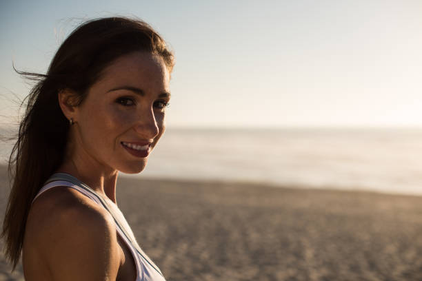 istock Woman enjoying beautiful sunset on the beach 1263901798