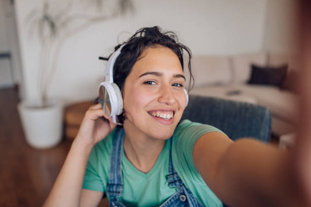 selfie de una chica linda con auriculares disfrutando de la música - attractive female only young women music living room fotografías e imágenes de stock