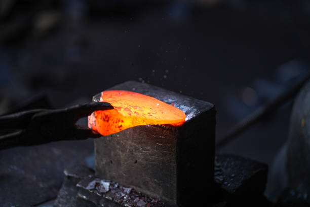 istock Worker forging and shaping metal with machine sparks, smoke 1263902024