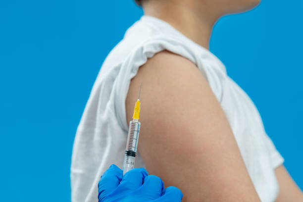 istock Doctor vaccinating for a boy on blue background 1263902950