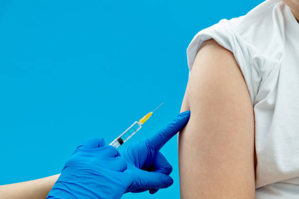 istock Doctor vaccinating for a boy on blue background 1263903060