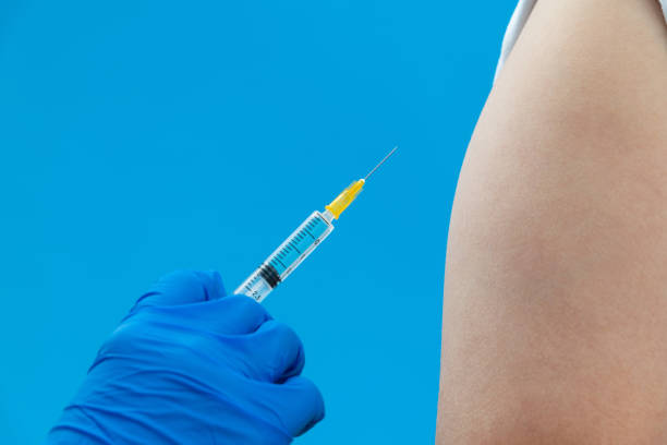 istock Doctor vaccinating for a boy on blue background 1263903128