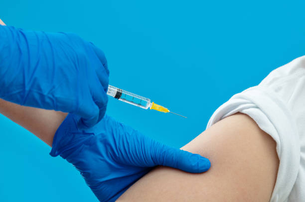 istock Doctor vaccinating for a boy on blue background 1263903450