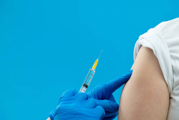 istock Doctor vaccinating for a boy on blue background 1263903453