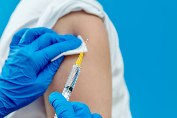 Doctor vaccinating for a boy on blue background