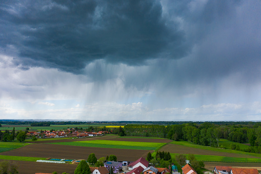 Storm clouds over rural landscape with agricultural fields and village houses