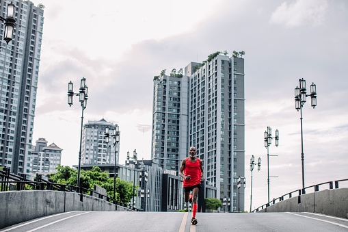 Senior man jogging in an urban area (wide angle, copy space).