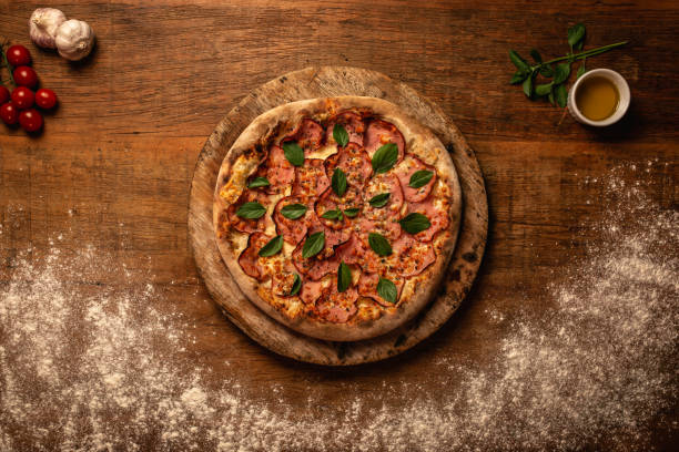istock Top down pizza on wooden table 1263908886