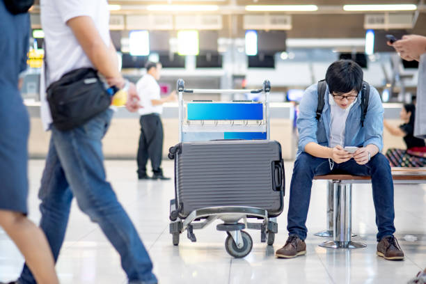 istock Asian man tourist using smartphone in airport 1263909184