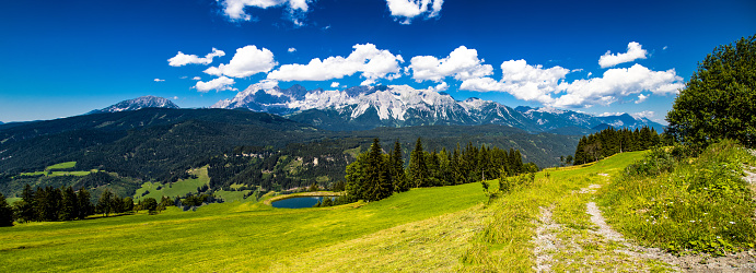 Panoramic photo taken on the Hochwurzen alm with Dachstein mountain in the background and alpine landscape