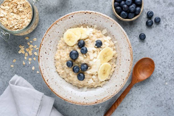 tazón de avena con plátano, arándanos, coco - porridge fotografías e imágenes de stock