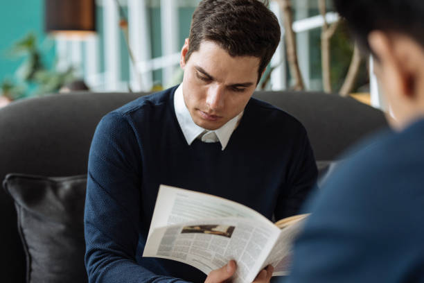 istock Young Businessman Reading a Newspaper at a Cafe 1263910726