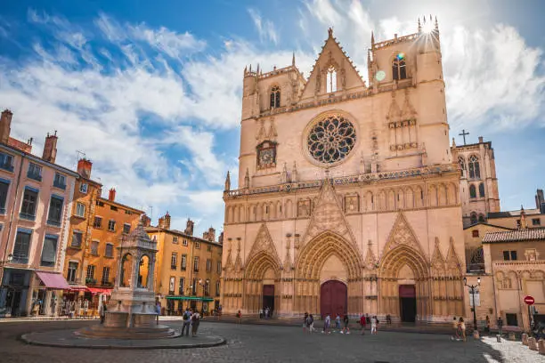 Majestic ancient architecture of Saint-Jean-Baptiste Cathedral monument in Lyon old town, in Vieux Lyon district with group of tourists. Photo taken in Lyon famous city, Unesco World Heritage Site, in Rhone department, Auvergne-Rhone-Alpes region in France, Europe during a sunny summer day.