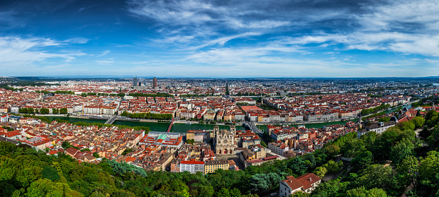 Wide panorama aerial view of Lyon cityscape with Saone and Rhone river, La Part-Dieu business district skyscrapers and buildings in background and hostoric monuments like St Jean Cathedral from Vieux Lyon district. Photo taken in Lyon famous city, Unesco World Heritage Site, in Rhone department, Auvergne-Rhone-Alpes region in France, Europe during a sunny summer day.