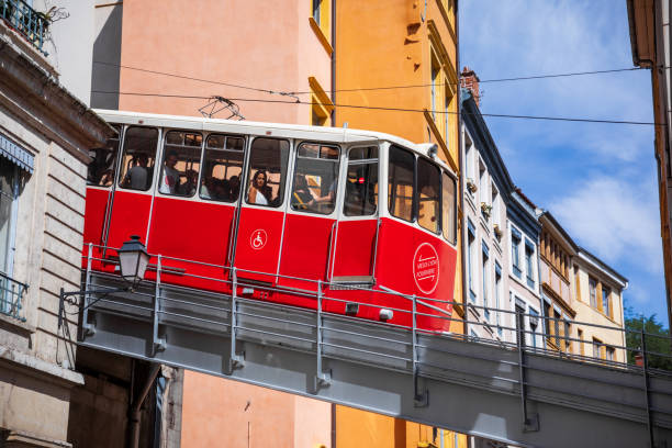 Exterior part of the old funicular also called La Ficelle in the streets of Vieux Lyon old town French city Exterior part of the old red funicular also called La Ficelle in the streets of Lyon old town, with silhouettes of tourists inside. Photo taken in Lyon famous city, Unesco World Heritage Site, in Rhone department, Auvergne-Rhone-Alpes region in France, Europe during a sunny summer day. fourviere stock pictures, royalty-free photos & images