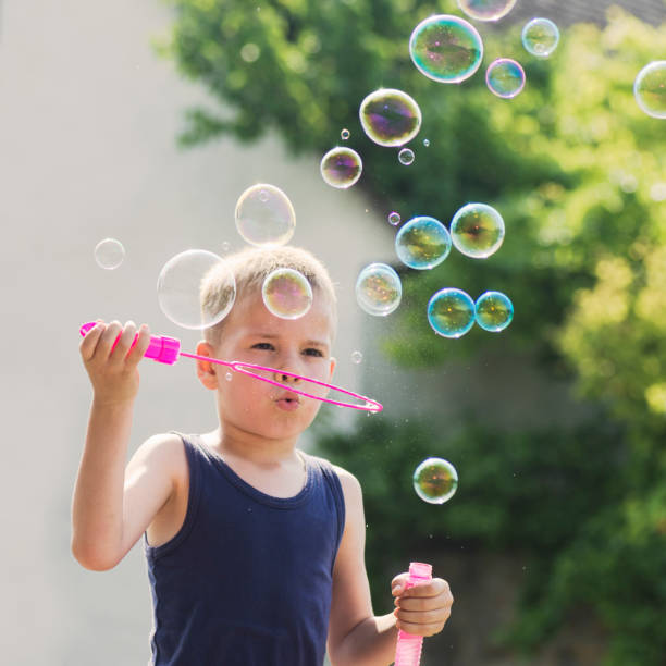 istock blond hair boy blowing soap bubbles 1263915648