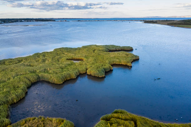 schönes drohnen-landschaftsbild von gezeiteneinlass am christchurch harbour an der englischen südküste während des sommerabends - tide aerial view wave uk stock-fotos und bilder