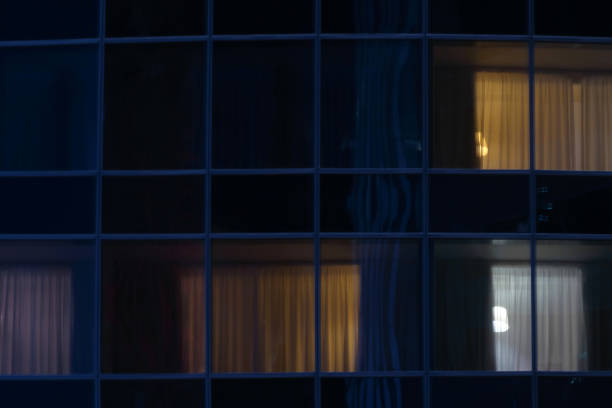 istock Light in some windows at night. Glass wall of modern building. 1263917468
