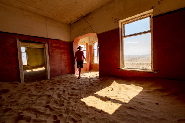 istock Man walking on sand covering house floor 1263918104