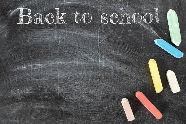 istock Inscription back to school on the wiped out old blackboard with crayons. Chalkboard with colorful pieces of chalk. Background horizontal composition, copy space. 1263923849