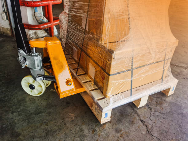 istock Worker driving forklift loading and unloading shipment carton boxes and goods on wooden pallet from container truck to warehouse cargo storage in logistics and transportation industrial 1263924371