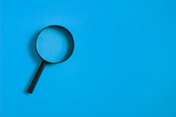 istock Magnifying Glass on Blue Background 1263924386