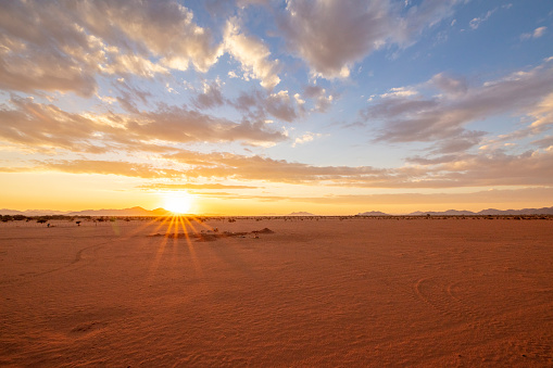 View of setting sun over sandy desert