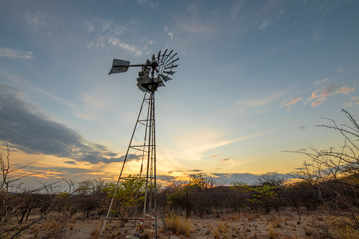 View of windmill at sunset in barren landscape