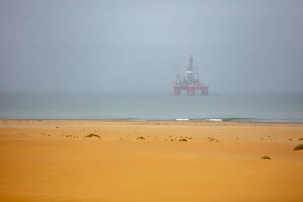 Oil drilling rig, gasoline tanker, oil Sstorage tank. technological area, Sakhalin island. Blue sky, dirty earth road, bad ecology