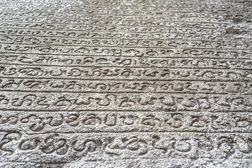 Sinhalese language stone book on wall of 12th century stone Hindu structure. Polonnaruwa, Sri Lanka.