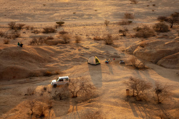 small green touristic tent  stay among sandy desert at the sunset