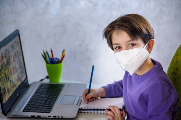 istock boy with computer does his homework during a coronavirus quarantine. concept of online education. Social distance, self- isolation. Distance learning due to virus, infection 1263930037