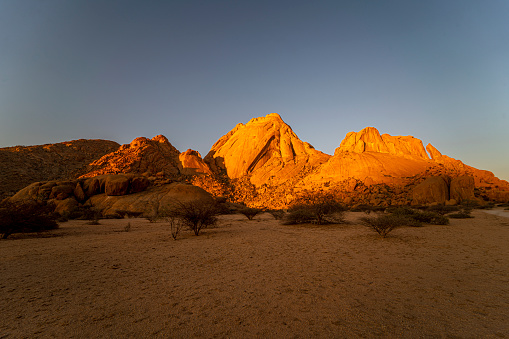 Desert landscape with eroded granite rock formation at sunset