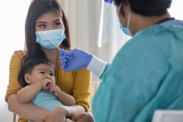 istock Doctor holds swab while explaining the Covid-19 test to patient 1263930333