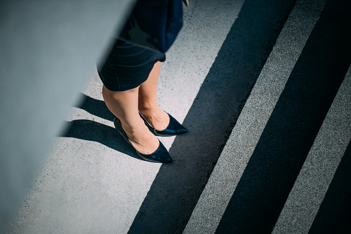 Close-up of woman's legs in high heels on sidewalk