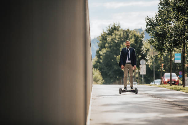 Man on hoverboard Man in suit riding on hoverboard along sidewalk hoverboard stock pictures, royalty-free photos & images