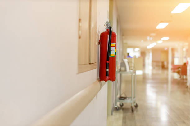 Fire extinguisher in the operating department . Install a fire extinguisher on the wall in building. Dry chemical powder fire extinguisher in corridor .a red fire-extinguisher hangs on wall . Fire extinguisher in the operating department . Install a fire extinguisher on the wall in building. Dry chemical powder fire extinguisher in corridor .a red fire-extinguisher hangs on wall . fire extinguisher photos stock pictures, royalty-free photos & images