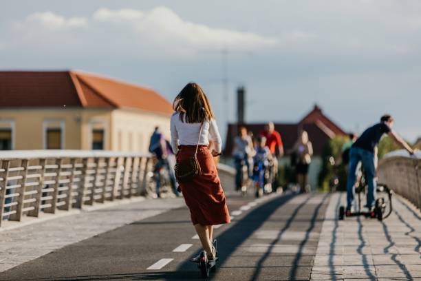 istock People walking and riding electric push scooters on bridge 1263932124