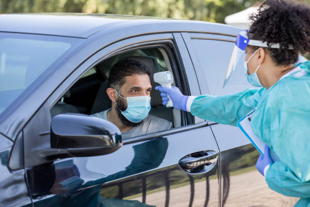 istock Nurse checks males temperature at drive through Covid-19 testing site 1263932908